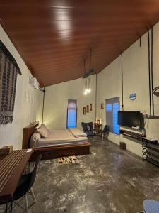 a large room with a bed and a tv at Loti Guest House in Kupang