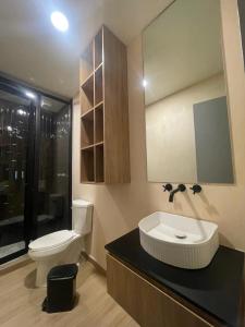 Un baño con un inodoro blanco y un lavabo. en Hostal Morada, en Puebla 36 fotos más