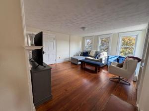 a living room with a couch and a tv at Seaside Stay in Historic Warren in Warren