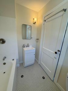 a bathroom with a shower and a sink and a mirror at Seaside Stay in Historic Warren in Warren