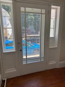 a room with two windows and a blue car outside at Seaside Stay in Historic Warren in Warren