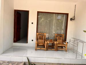 two chairs and a table on a porch at PAN Homestay in Kuta Lombok