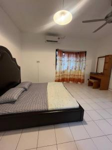 Un dormitorio con una cama y un ventilador de techo. en REV Homestay Taman Indah Permai, en Gua Sai
