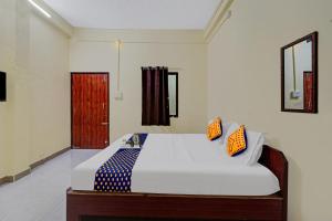 a bedroom with a bed with two pillows on it at Hotel O KVR Residency in Chennai