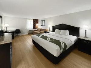 a hotel room with a large bed and a desk at 1734 West Hotel in Fort Wayne