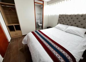 a bedroom with a large bed and a bathroom at Hotel Inka House Chinchero in Chinchero +23 photos