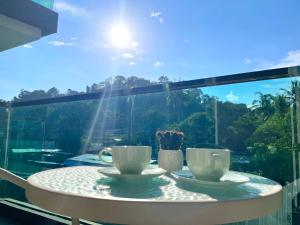 a table with two coffee cups on a balcony at Bright 2BR Condo near Central Phuket FREE Pool Gym Parking in Ban Ket Ho