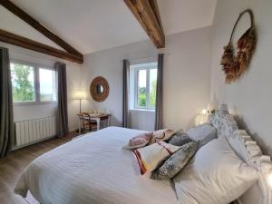 a bedroom with a large white bed with pillows at Gîte de charme pour 5 pers. avec terrasse privative dans la Loire - FR-1-496-375 in Grézieux-le-Fromental