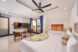 a bedroom with a bed and a dining room at CocoPalm Hoi An River Beach in Hoi An