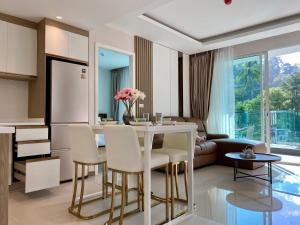 a kitchen and living room with a table and chairs at Bright 2BR Condo near Central Phuket FREE Pool Gym Parking in Ban Ket Ho