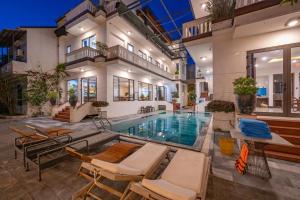 a house with a swimming pool with chairs and a house at CocoPalm Hoi An River Beach in Hoi An