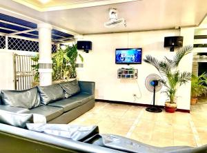 a living room with a couch and a flat screen tv at La Roma - Hot Spring Private Resort in Pansol