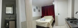 a small room with a small bed and a sink at Pousada Hotel Sol Nascente in Mafra