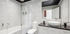 a bathroom with a toilet and a sink and a shower at PENTHOUSE at OZONE in Queenscliff +11 photos