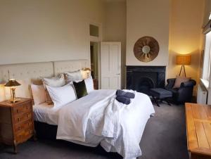 a bedroom with a large white bed and a fireplace at PENTHOUSE at OZONE in Queenscliff