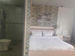 a bed with white sheets and pillows in a bedroom at Đối diện cafe CATINAT villa Kagen in Da Lat