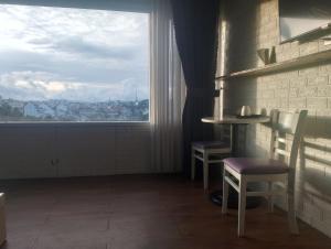 a room with a table and chairs and a window at Đối diện cafe CATINAT villa Kagen in Da Lat