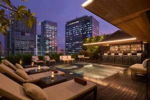 a rooftop patio with a hot tub and a city skyline at Silverland Sakyo Hotel in Ho Chi Minh City