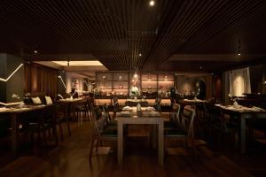 a restaurant with tables and chairs in a room at Silverland Sakyo Hotel in Ho Chi Minh City