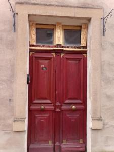 a red door with two windows on top of it at Le couvent des Capucines - Dortoir vélo Via Rhona - Les petites Féés in Saint-Vallier +7 photos