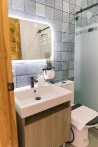 a bathroom with a sink and a toilet and a mirror at Emavel Beach Resort in Balaoan