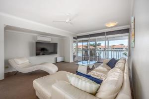 a living room with a white couch and a tv at The Whitehouse - South Yunderup in South Yunderup