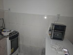 a small kitchen with a stove and a microwave at Kitnet temporada in Belém