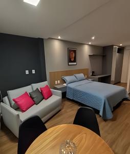 Un dormitorio con una cama, un sofá y una mesa. en Art Stúdio Beira-Mar em Armação 123, en Salvador