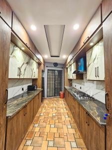 a kitchen with wooden cabinets and a tile floor at Noor Residence Cozy Homes G15 in Islamabad