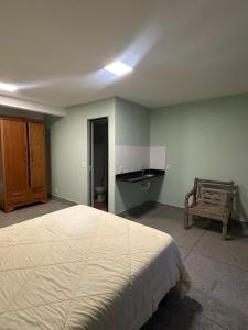 ピレノポリスにあるEsquina Da Mataの大きなベッドと洗面台のある寝室