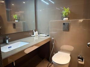 a bathroom with a sink and a toilet and a mirror at Bloom Studio Suites in Raipur +10 photos