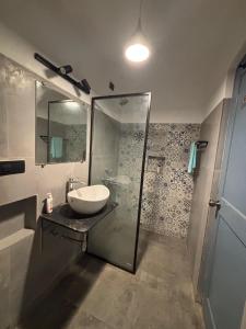 a bathroom with a sink and a shower at Candolim apartment in Candolim