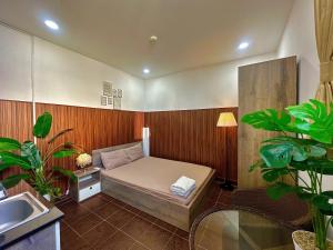 a small bedroom with a bed and a sink at Taibo-house in Ho Chi Minh City