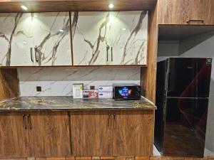 a kitchen with a counter top and a refrigerator at Noor Residence Cozy Homes G15 in Islamabad +49 photos