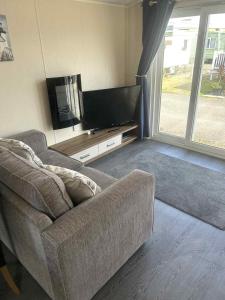a living room with a couch and a flat screen tv at Newton Beach retreat in Porthcawl