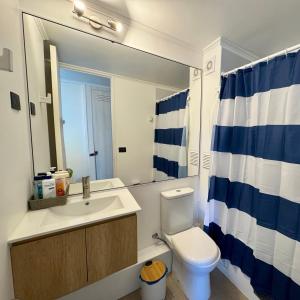 Un baño con lavabo, inodoro y espejo. en Home Studio La Serena, en La Serena 8 fotos más