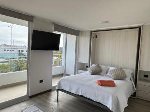 Un dormitorio con una cama y un televisor de pantalla plana. en Home Studio La Serena, en La Serena
