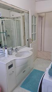 a white bathroom with a sink and a mirror at Oxi in Modena +17 photos