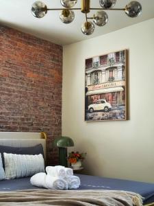 a bedroom with a brick wall and a picture of a car at 2 BEDS Free Parking Right Where You Want to Be in Pittsburgh