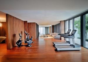 a gym with treadmills and exercise bikes in a room at Arvesto Lux Jakarta in Jakarta
