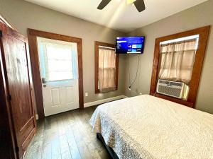 a bedroom with a bed and a flat screen tv at Feline Twins in New Orleans +16 photos