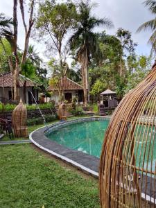 un complexe avec une piscine dans une cour dans l'établissement The Chapel Alam Sari Ubud, à Ubud