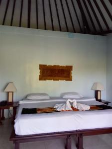 two beds sitting next to each other in a room at The Chapel Alam Sari Ubud in Ubud
