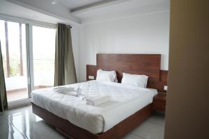 a bedroom with a large bed and a large window at Pearl Residency Kalady in Kāladi