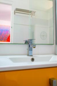 a bathroom sink with a mirror and a faucet at chez marvin in Pointe-à-Pitre