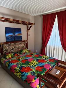 a bedroom with a bed with a colorful comforter at Location studio Maeva Lodge in Faaa