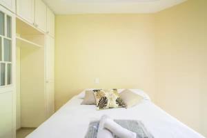 a bedroom with a bed with white sheets and pillows at Quarto Centro SP, Rua 25 de Março, Piscina in Sao Paulo +8 photos