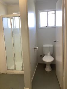 a bathroom with a toilet and a window at Quiet, Charming 3BR in Moranbah +3 photos