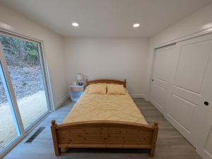 une chambre avec un lit et une grande fenêtre dans l'établissement Redwood Haven Your Santa Cruz Mountains Gateway, à Los Gatos