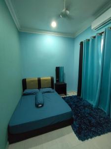 a bedroom with a bed with blue walls and a rug at Homestay MamaYa Tok Bok in Machang